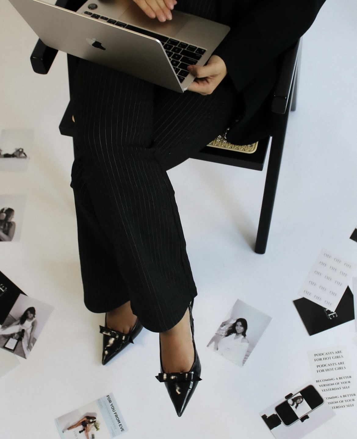 Editorial branding portrait with laptop, pointed heels, and printed campaign pieces