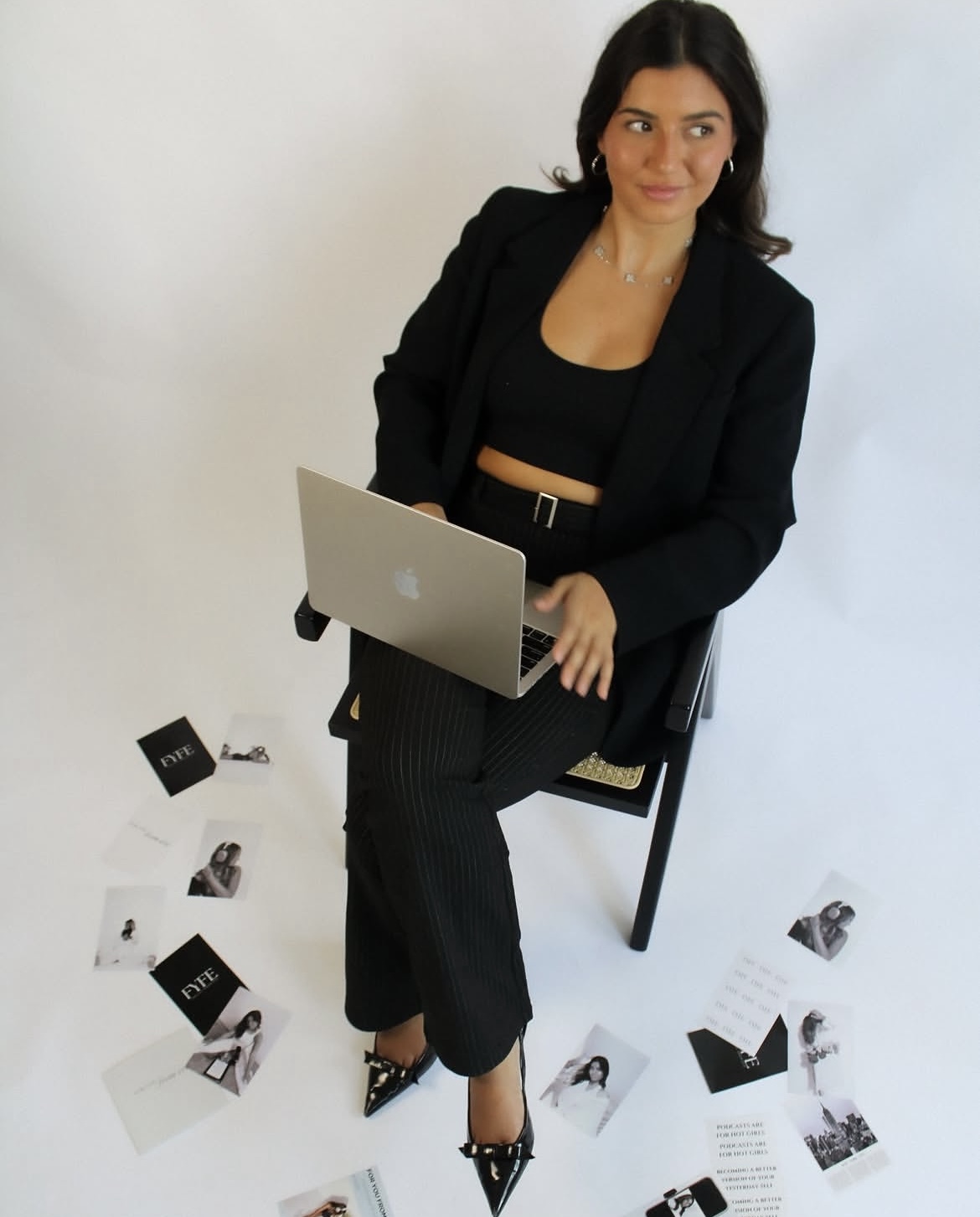 Brand founder seated with laptop in a clean black-and-white branding setup