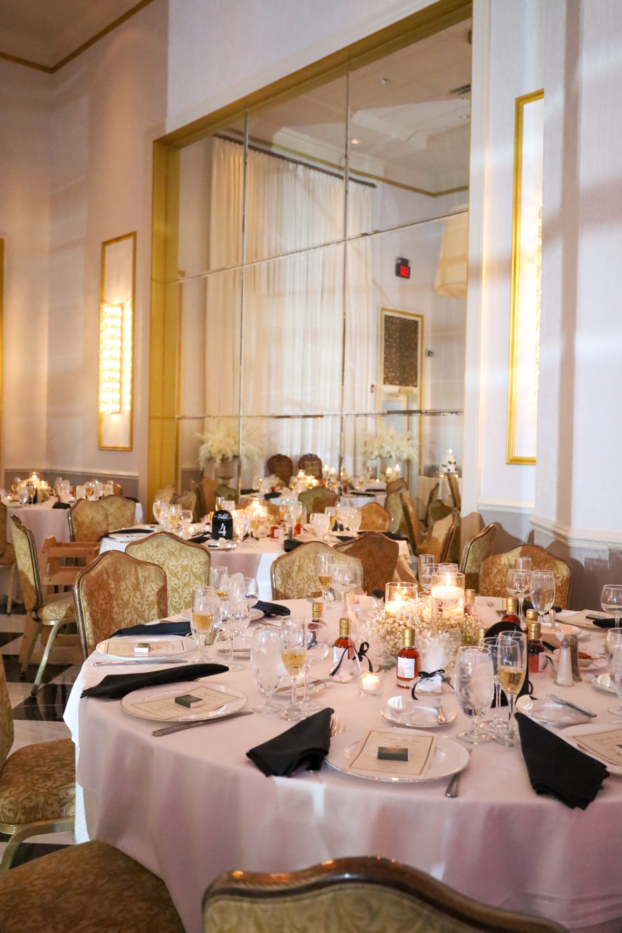 Candlelit reception table set with menus, florals, and champagne