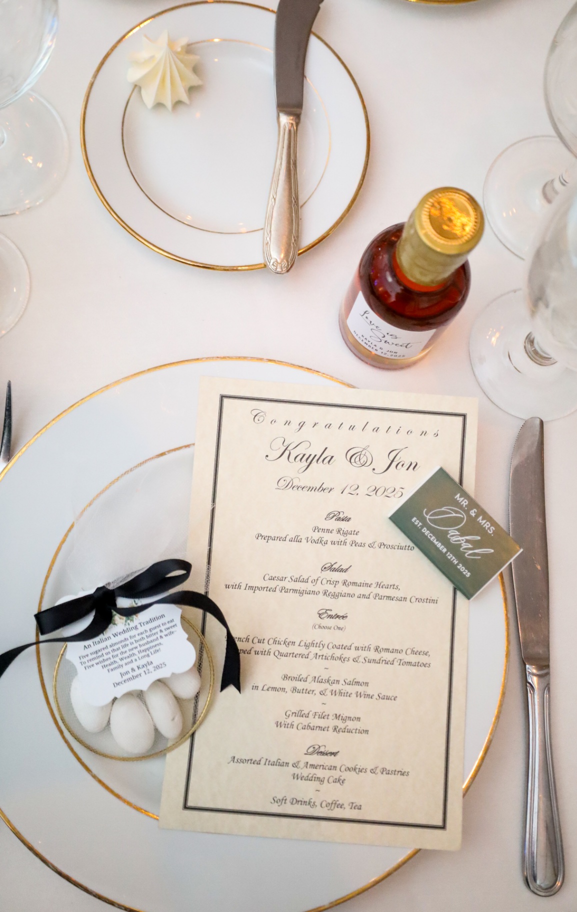 Gold-rimmed wedding place setting with custom menu and almond favors