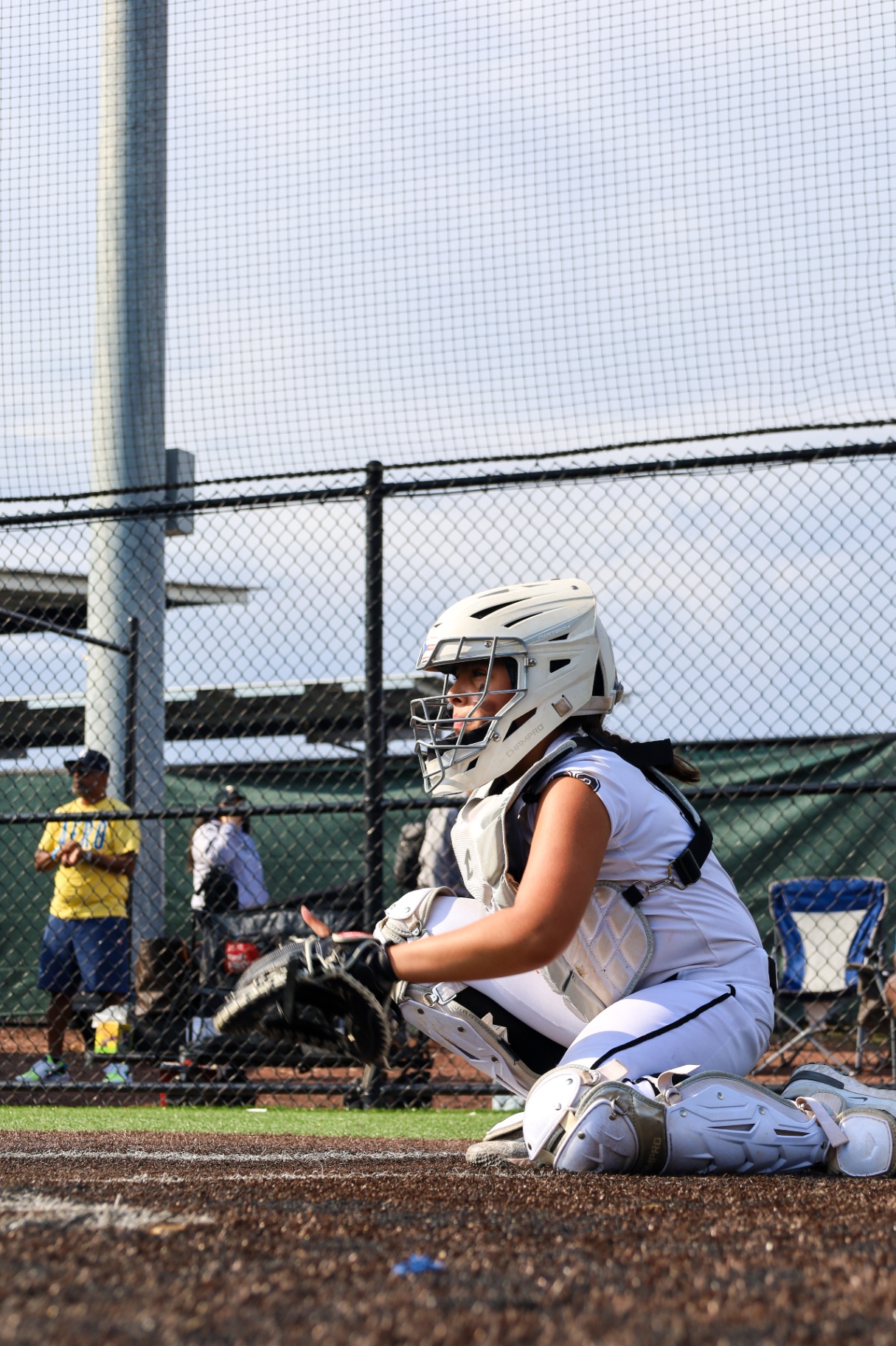 Softball catcher kneeling ready to receive a pitch