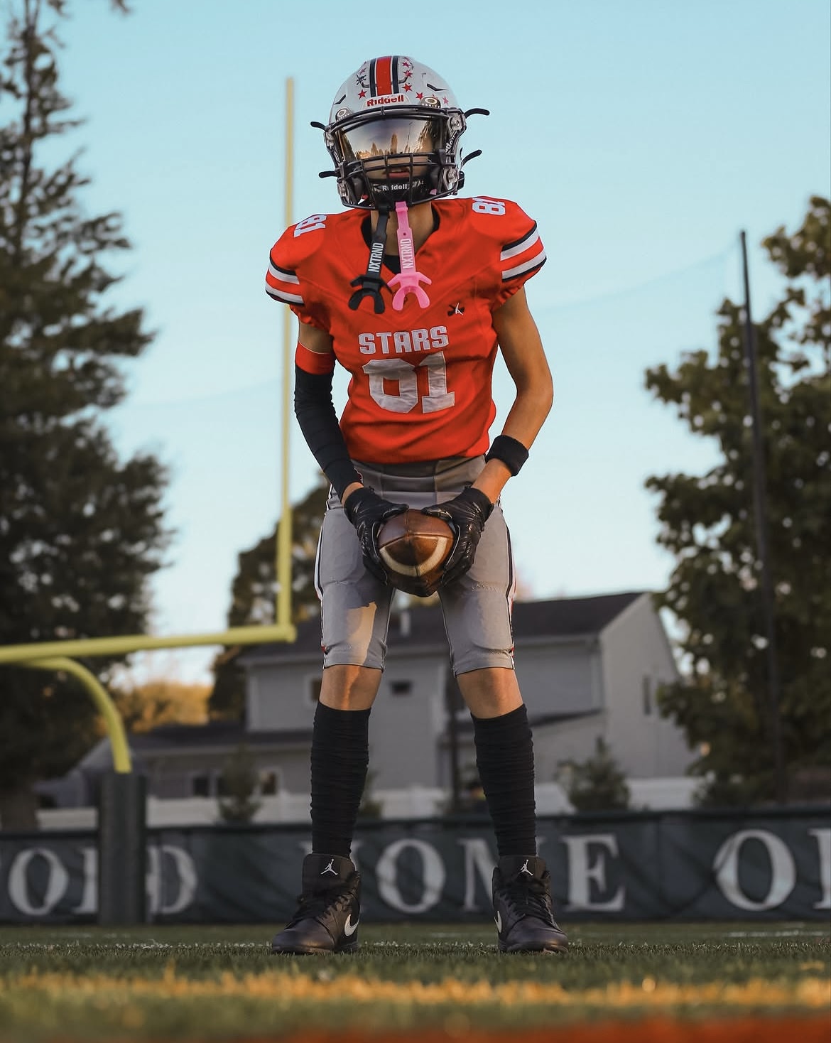 Stars football player number 81 posing with the ball at sunset