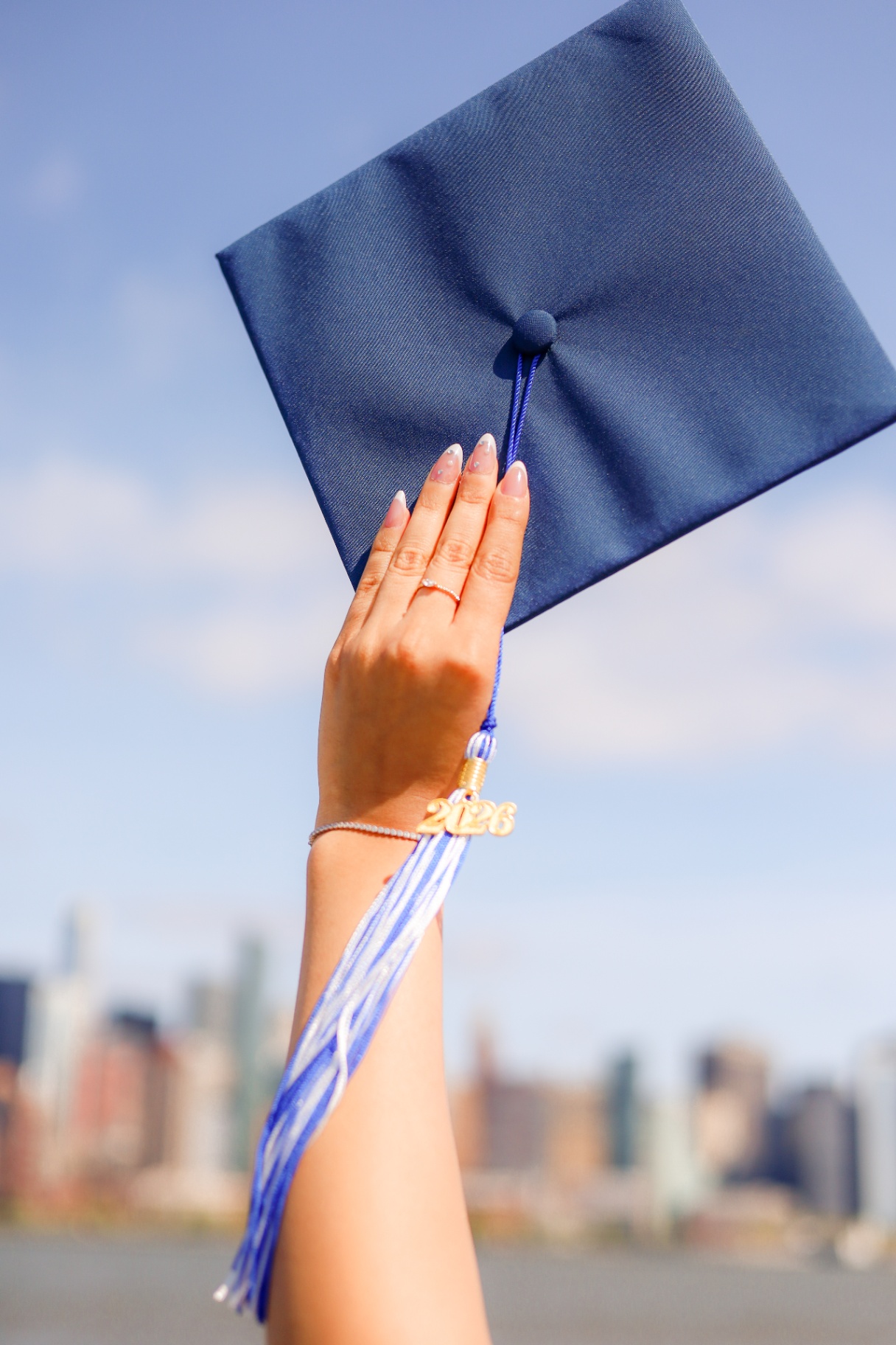 Class of 2026 graduation cap held up against the sky