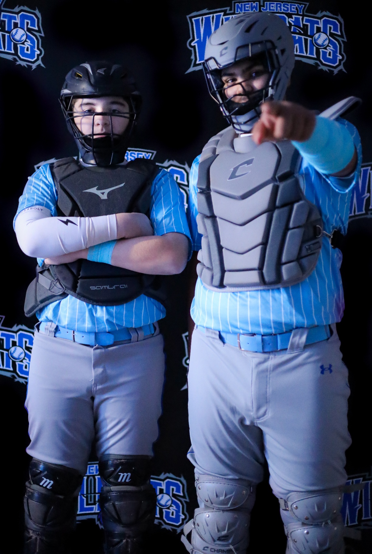 Two youth catchers posing together in matching uniforms