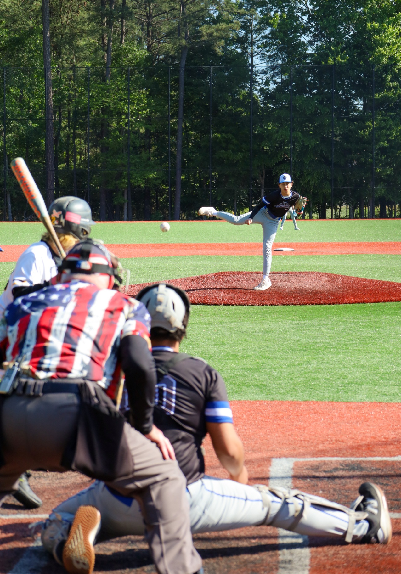Baseball pitcher mid follow-through viewed from behind the catcher